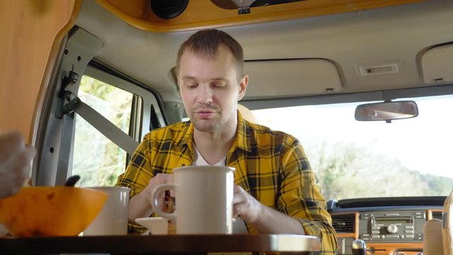 maman eating meat at a table in a motorhome. car travel concept