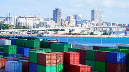 container site in the port against the background of the sea and the Japanese city with skyscrapers. multi-colored containers in an industrial port. worldwide shipping