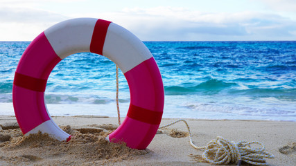 bright lifebuoy on a background of blue ocean water. life buoy on the beach. safety when swimming in the sea and ocean