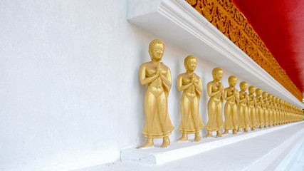 Row of golden Buddhas, perspective with free space
