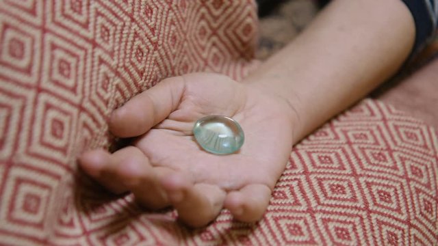 A clear obsidian crystal is placed into a hand during crystal healing