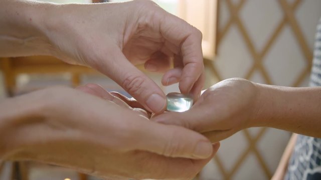 A clear obsidian crystal is placed in a clients hand. 60fps