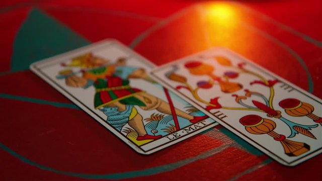 Close up of &lsquo;Le Mat&rsquo; (The Fool) tarot card on a table as others are laid down around it