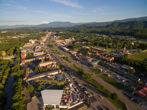 The setting sun cast bright highlights on the various attractions of Pigeon Forge Tennessee. A drone, birds eye, aerial angled view.