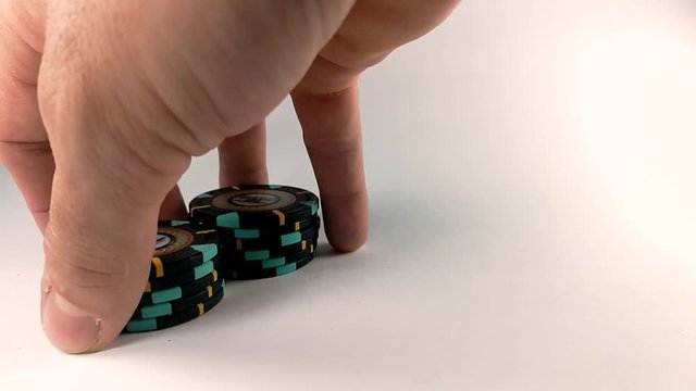 Male hand shuffling black poker chips on a white table, STILL, ISOLATED, SLOMO