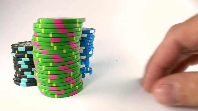 Male hand moving stacks of poker chips across the white table, ISOLATED, SLOMO, STILL