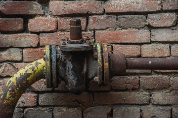 Fototapeta na wymiar Pipe without valves on a brick wall background