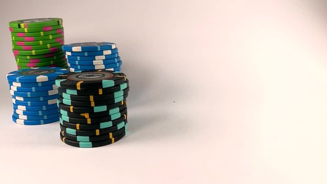 Male hand moving a black stack of poker chips across the white table, ISOLATED, STILL