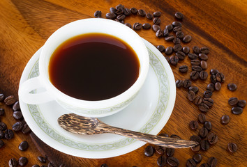 Black coffee in white coffee cup on vintage wooden table background