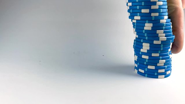 Male finger pushing down a stack of blue poker chips, ISOLATED, STILL, SLOMO