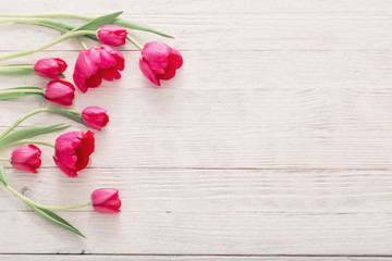 Naklejka na ściany i meble pink tulips on white wooden background