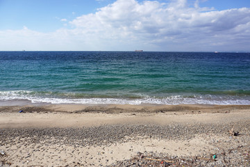 遠くにタンカーのある晴れた海の水平線