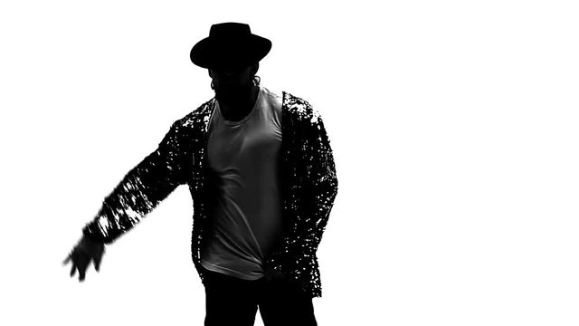 Silhouette of a young man dancer dancing in style Michael Jackson on white background. Close up, slow motion.