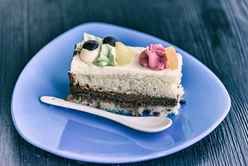 Sponge cake with cream on a wooden background.