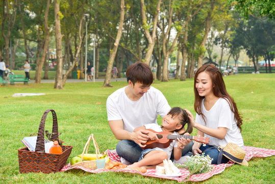 Portrait Of Happy Asian Family In Garden