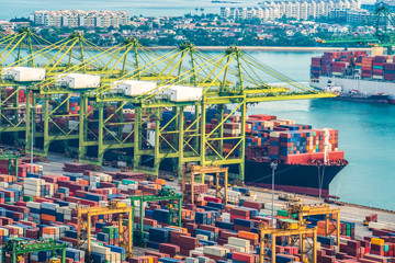 Container Cargo freight ship with working crane loading bridge in shipyard at dusk for Logistic Import Export background