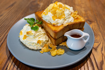honey toast with ice cream and whip cream in dish on the wooden table