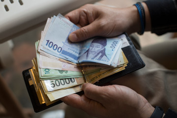 Hand holding South korean Won banknotes isolated