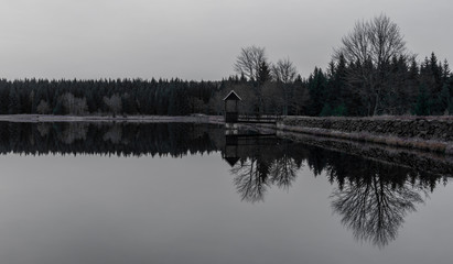 Ponds in Krusne hory mountains in winter cloudy evening
