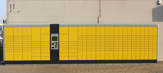 Self service very long yellow modern standard city parcel terminal installed near city market