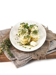 boiled young potatoes with dill and butter in a rustic style on a white background isolated