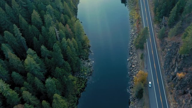 Aerial: Flying over a pine forest, highway and river in the Nez Perce Clearwater National Forests, Idaho, USA