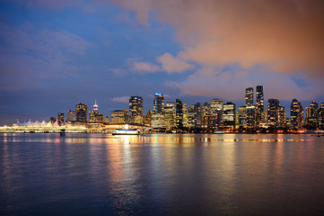 View of buildings illuminated in the city on coastline from Stanley park at Vancouver