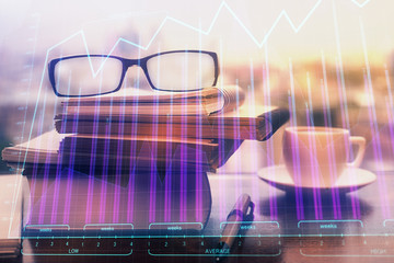 Financial graph hologram with glasses on the table background. Concept of business. Double exposure.