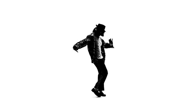 Silhouette of a young man dancer dancing in style Michael Jackson on white background. Close up, slow motion.