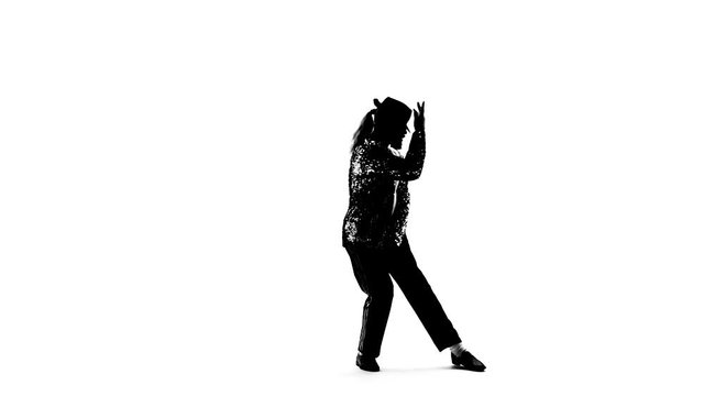 Silhouette of a young man dancer dancing in style Michael Jackson on white background. Close up, slow motion.
