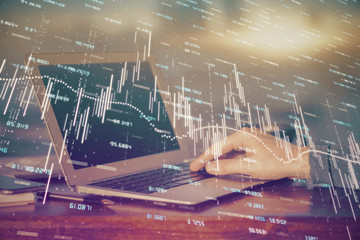 Double exposure of stock market graph with man working on laptop on background. Concept of financial analysis.