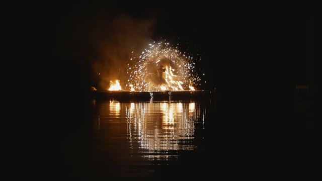 Fire show. artists dance with fire at night on water. a beautiful reflection in the water. Fireworks