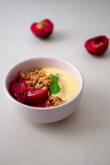 Fresh bright red plum crumble in the pink bowl