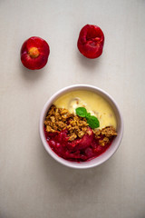 Fresh bright red plum crumble in the pink bowl