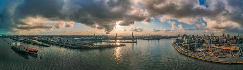 Panoramic drone aerial view of port of Hamburg from Hafencity before sunset with dramatic stormy clouds