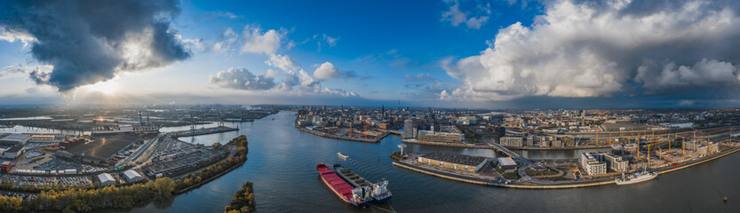 Fototapeta na wymiar Aerial drone panoramic view of port of Hamburg from above before sunset with dramatic stormy clouds over the sea port