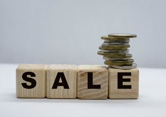 Business concept. word sale on cubes with coins