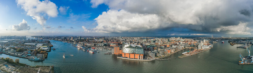 Fototapeta na wymiar Aerial drone panoramic view of port of Hamburg from above before sunset with dramatic stormy clouds over the sea port
