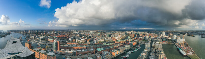 Fototapeta na wymiar Aerial drone panoramic view of port of Hamburg from above before sunset with dramatic stormy clouds