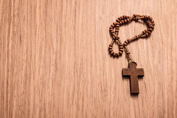 CLOSE UP OF A WOODEN ROSARY ON TABLE
