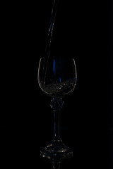 Wine in beautiful vintage crystal glasses on black wall background, with copy space. Wine list, bar drink menu, wine boutique or degustation, square crop concept. Water is poured into a glass