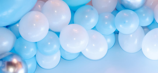 Colorful balloons background, punchy pastel colored and soft focus. Blue, white and silver balloons photo wall birthday decoration