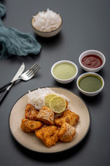 Boneless fried fish served with green sauce and dip