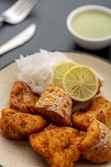 Boneless fried fish served with green sauce and dip