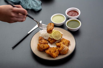 Boneless fried fish served with green sauce and dip
