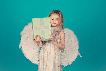 Wonderful blonde little girl in the image of an angel with white wings. Little angel Girl in white...