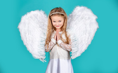 Child with angelic face. Cute child girl posing with angel wings. Beautiful little angel girl...