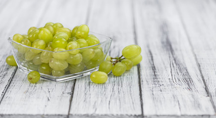 Wooden table with White Grapes (detailed close-up shot; selective focus)