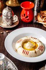 Arabian cuisine. Chickpea hummus with olive oil in a white plate. Serving dishes in an Arab restaurant. Background image. copy space