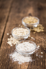 Old wooden table with fresh Oat Flour (close-up shot; selective focus)